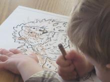 Child coloring a groundhog picture.